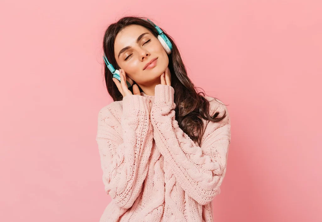brunette girl with pleasure listens music headphones woman pink outfit smiling isolated background 197531 13551